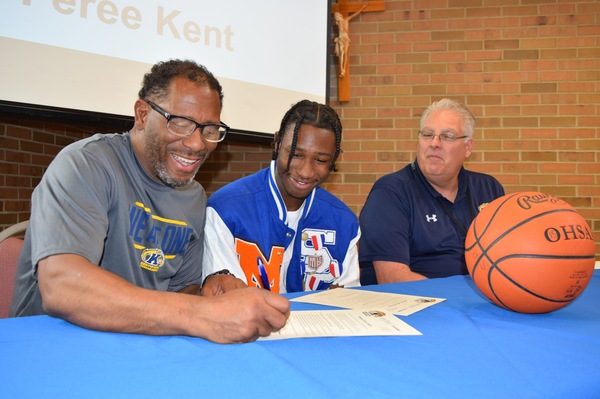 Feree Kent (center) watches while his father Ahmed co-signs his Letter of Intent while KSU Tusc Coach Richard Tharp looks on.