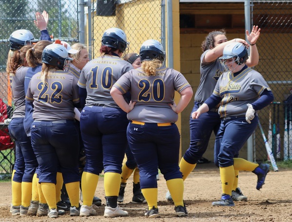 Jorden Moore is greeted at home plate after slugging her first-ever career grand slam.   PHOTO by Memories by Lois