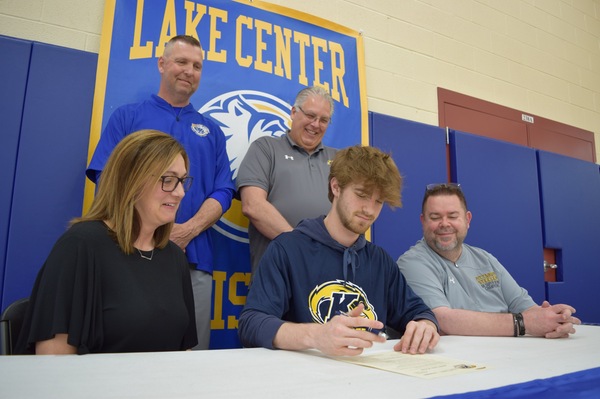 Signing a Letter of Intent is Ethan Bower (middle) seated between his mother Amy and his father Jonathan. Witnessing from the back row are Lake Center Christian Head Coach Greg Bryte and KSU Tuscarawas Head Coach Richard Tharp.