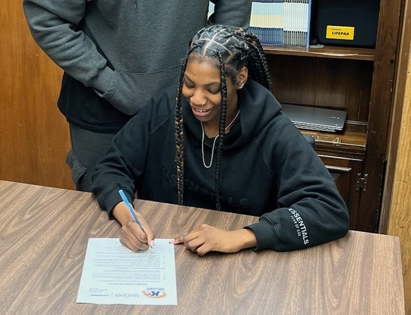 Melvindale Academy's Alexis Wilkes signs her Letter of Intent to play basketball for KSU Tusc. (Photo courtesy Melvindale Athletics)